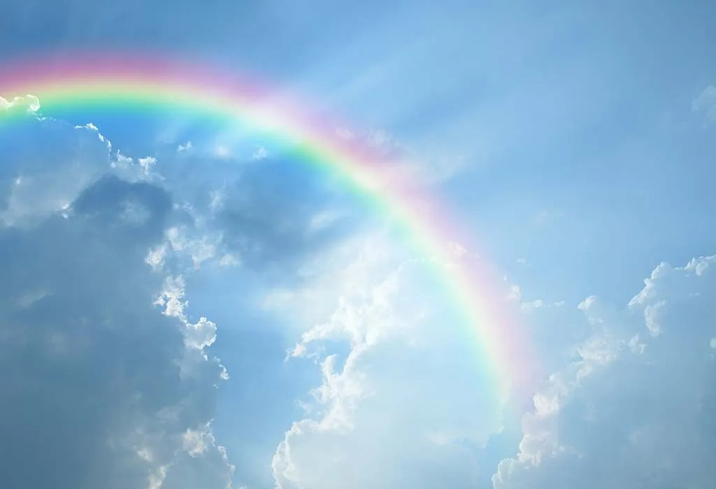 A beautiful rainbow in a blue cloudy sky