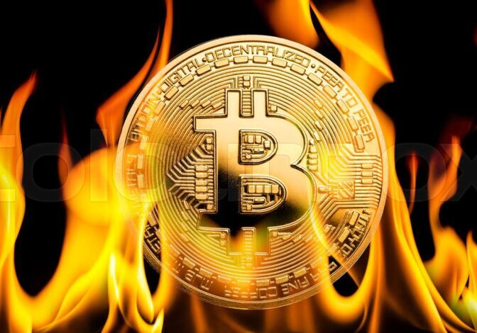 A burning bitcoin with black background