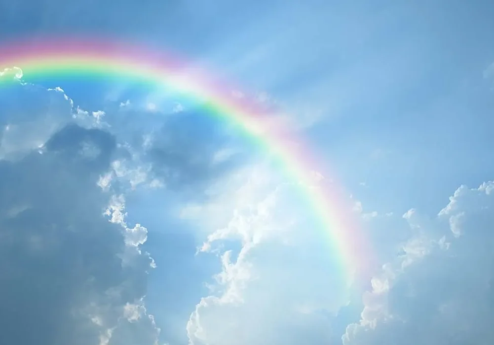 A beautiful rainbow in a blue cloudy sky